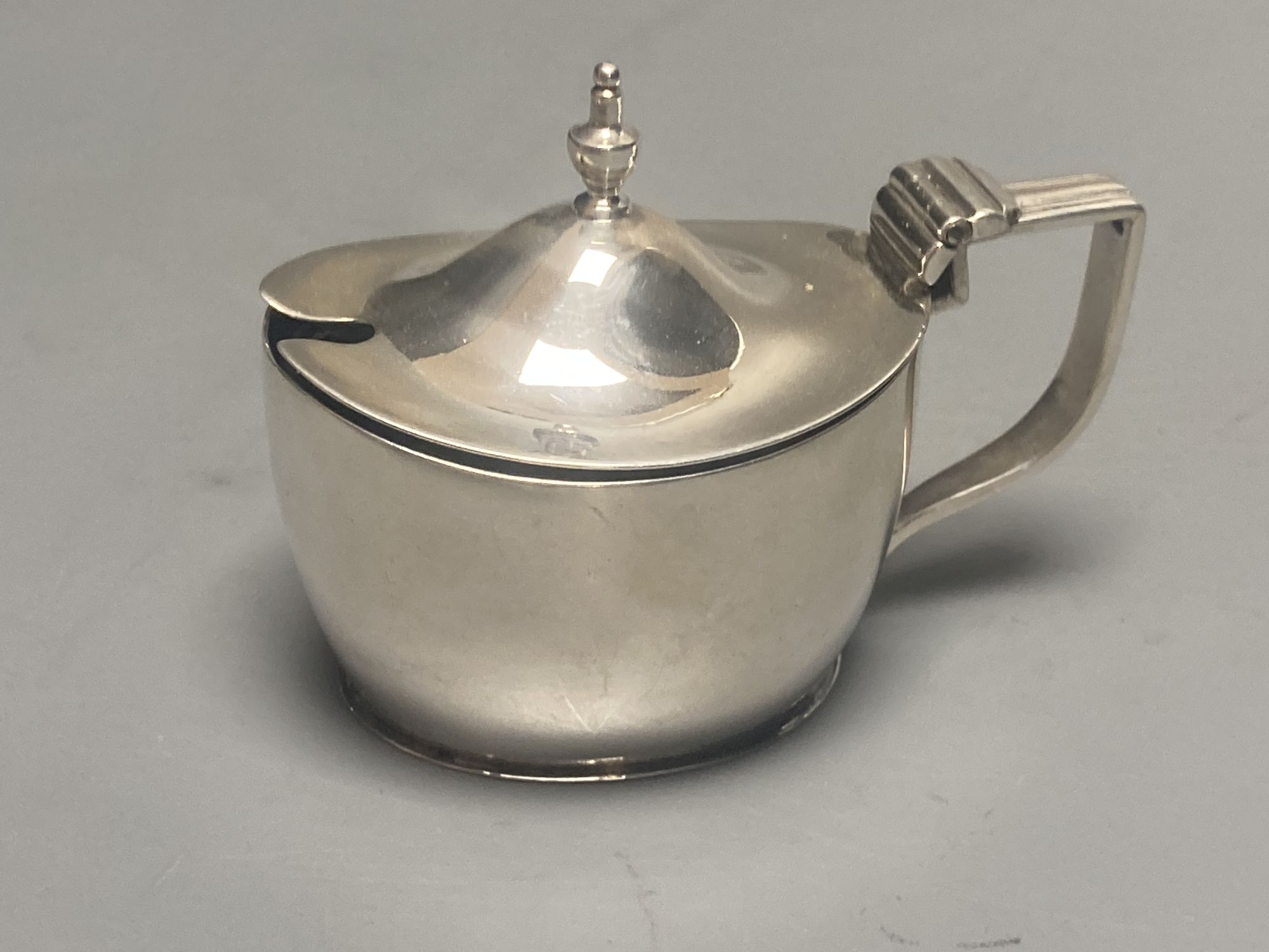 A late Victorian demi fluted silver mustard pot, London, 1894 and four other assorted later silver mustards.